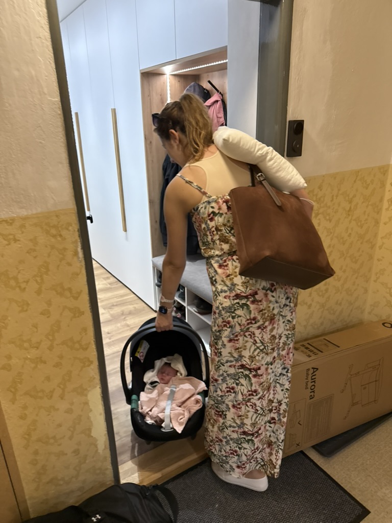 Máma přináší Ninu ve vajíčku do předsíně bytu