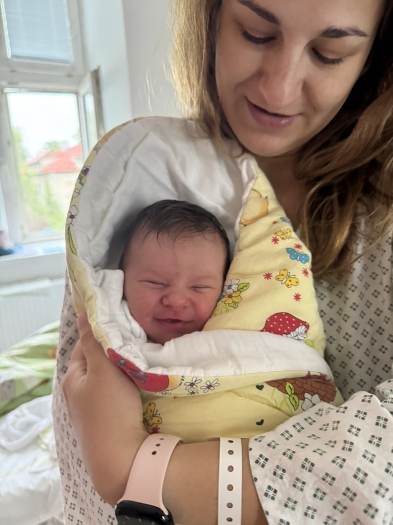 Nina pár hodin po narození, zabalená v náručí u mámy